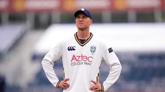 Cricketer in white kit looking upwards on field Cricketer in white kit looking upwards on field