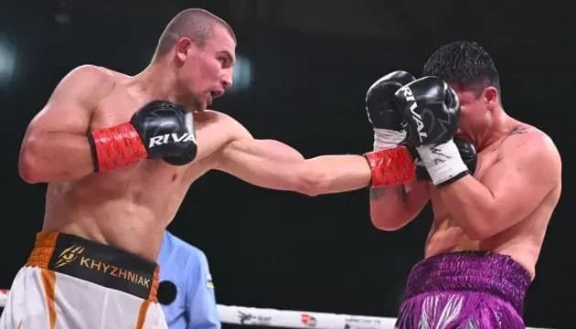 Boxer delivering a punch to opponent in ring Boxer delivering a punch to opponent in ring
