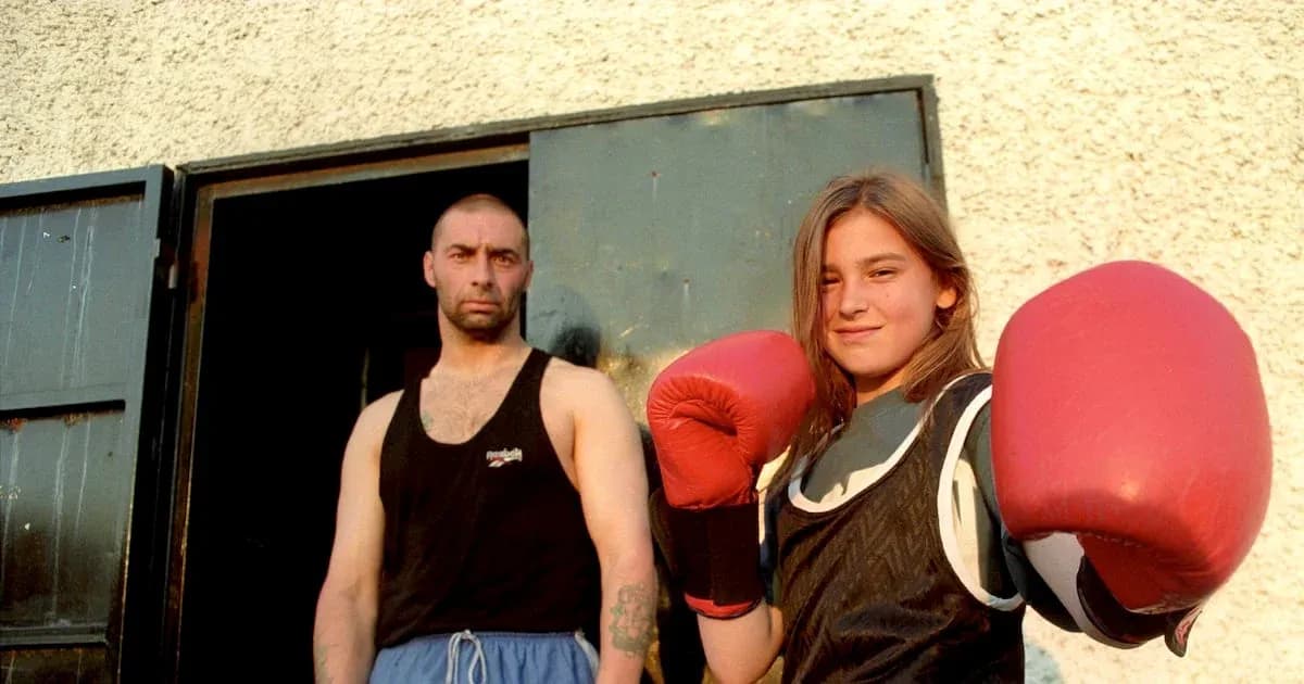 Young female boxer posing with gloves and coach Young female boxer posing with gloves and coach