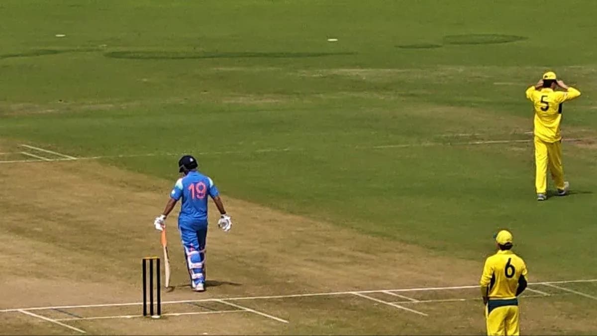 Batsman in blue uniform walking towards the wicket Batsman in blue uniform walking towards the wicket