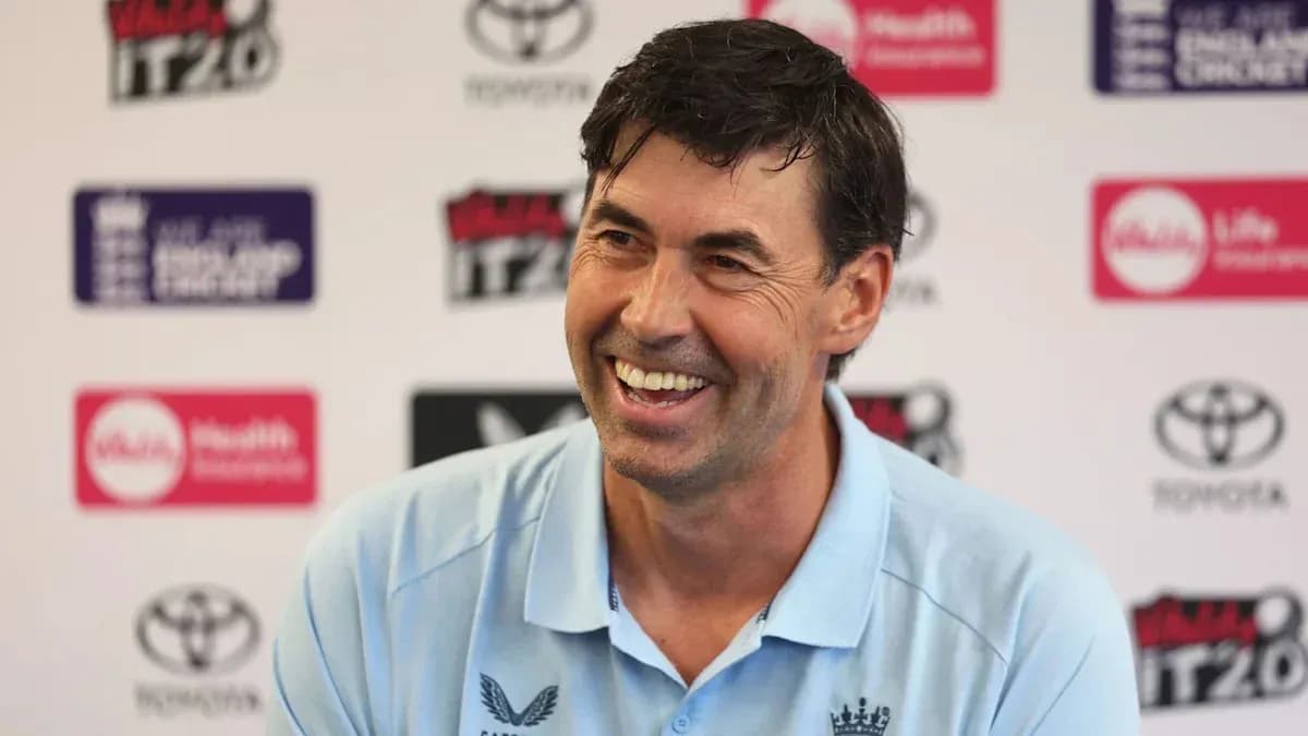 Cricket coach smiling at press conference Cricket coach smiling at press conference
