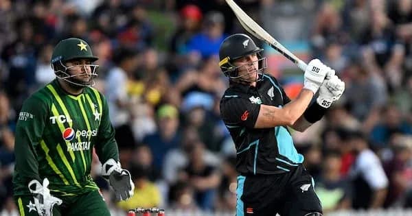 Batsman hitting ball while wicketkeeper watches Batsman hitting ball while wicketkeeper watches