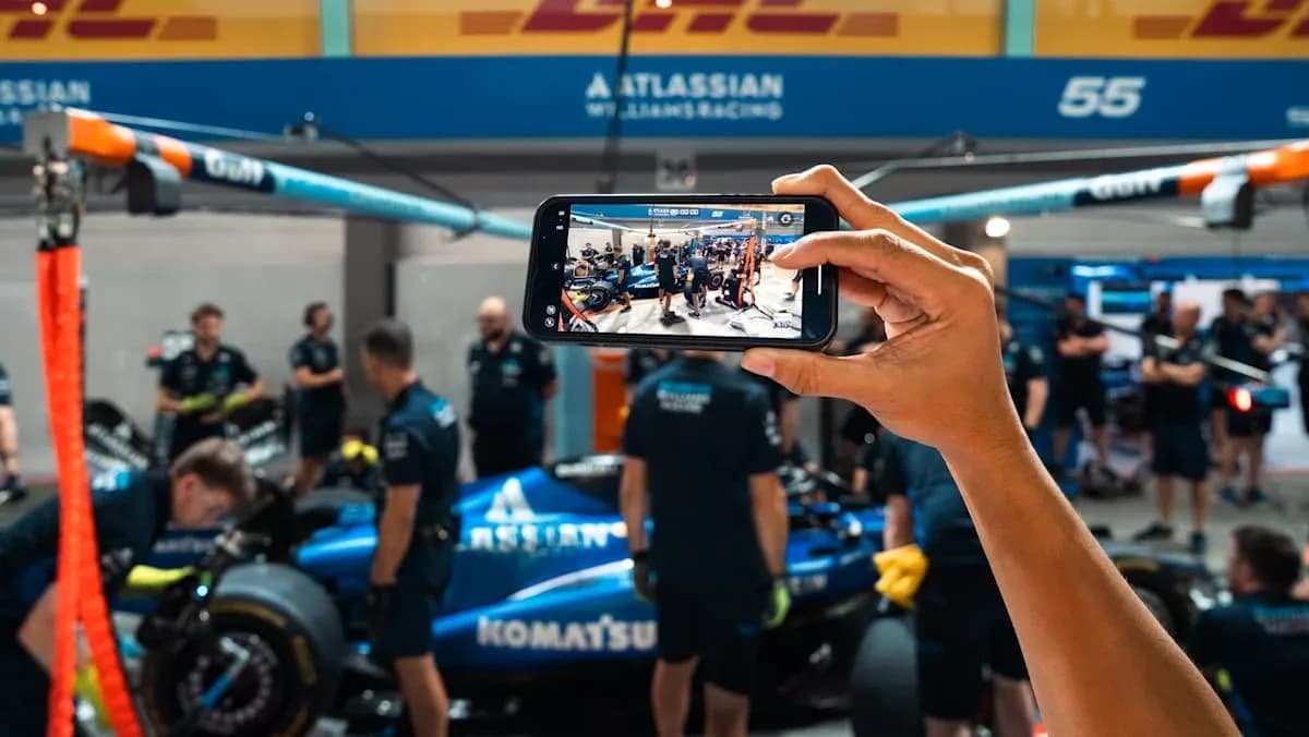 Person photographing Williams Racing team in garage Person photographing Williams Racing team in garage