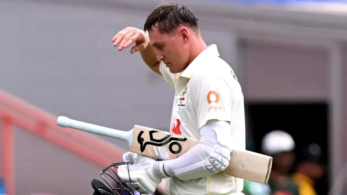 Cricketer walking off the field with bat in hand Cricketer walking off the field with bat in hand