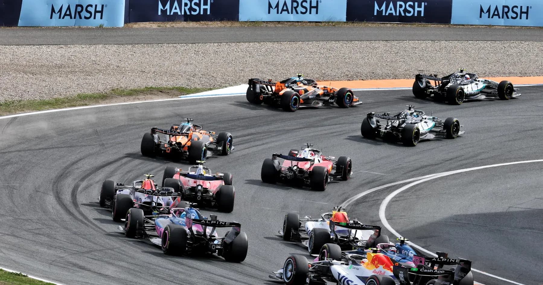 Formula 1 cars racing around a corner on track Formula 1 cars racing around a corner on track