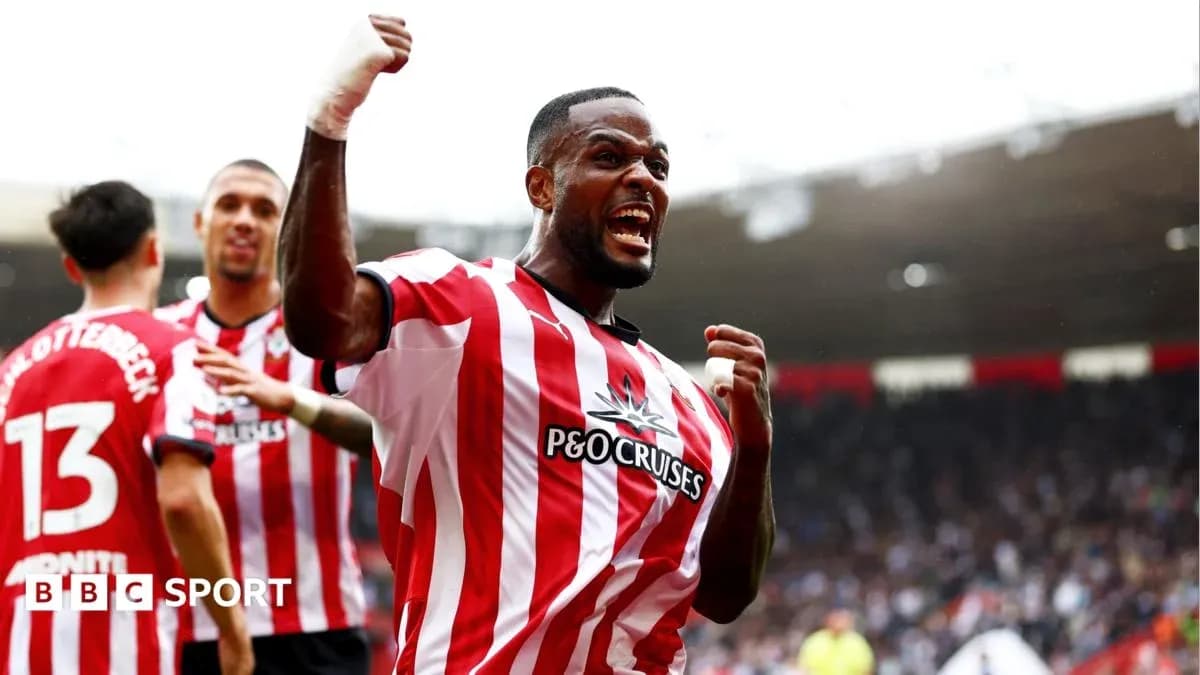 Player celebrating a goal with teammates on pitch Player celebrating a goal with teammates on pitch