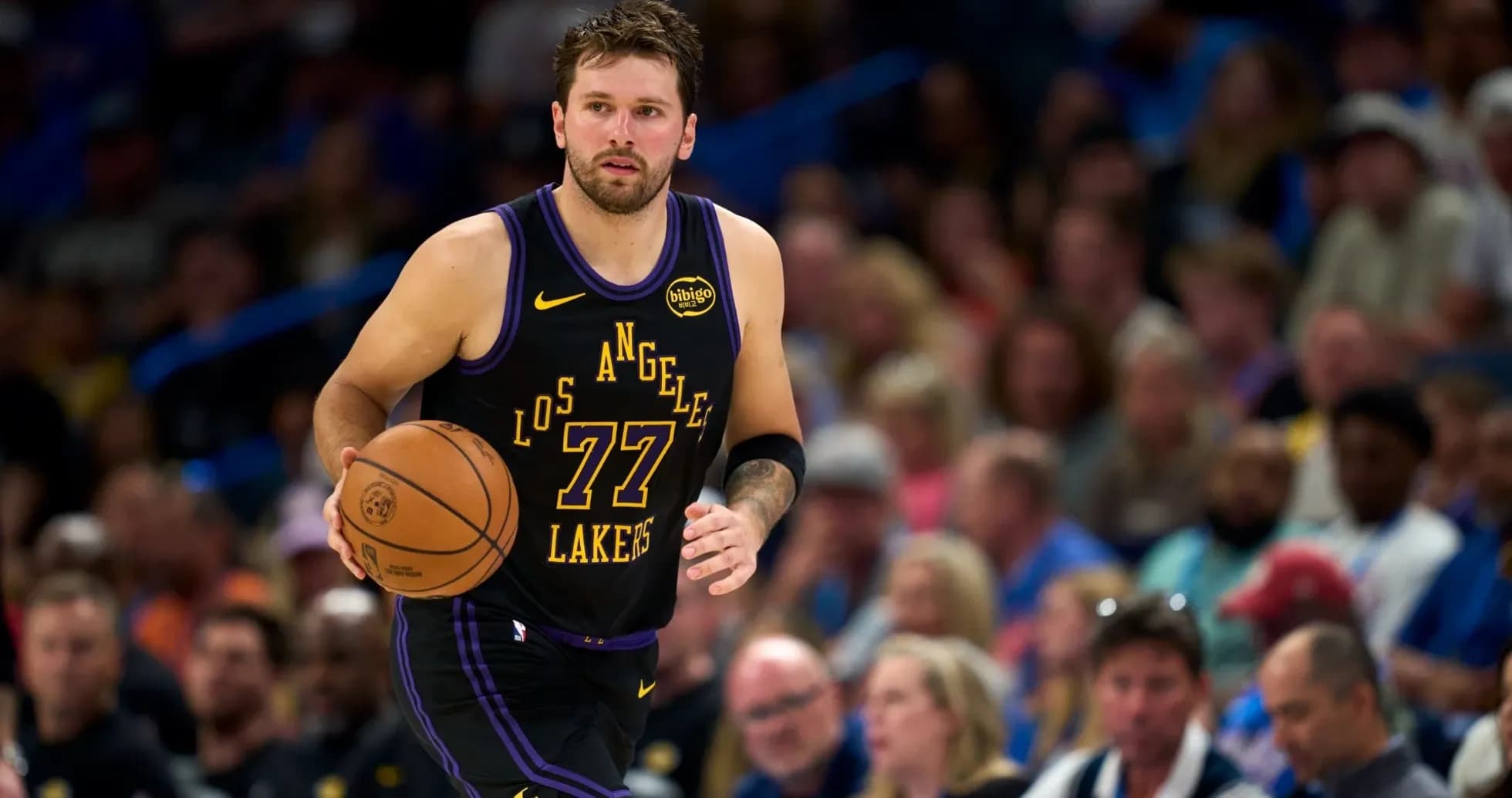 Player dribbling basketball during game against crowd Player dribbling basketball during game against crowd
