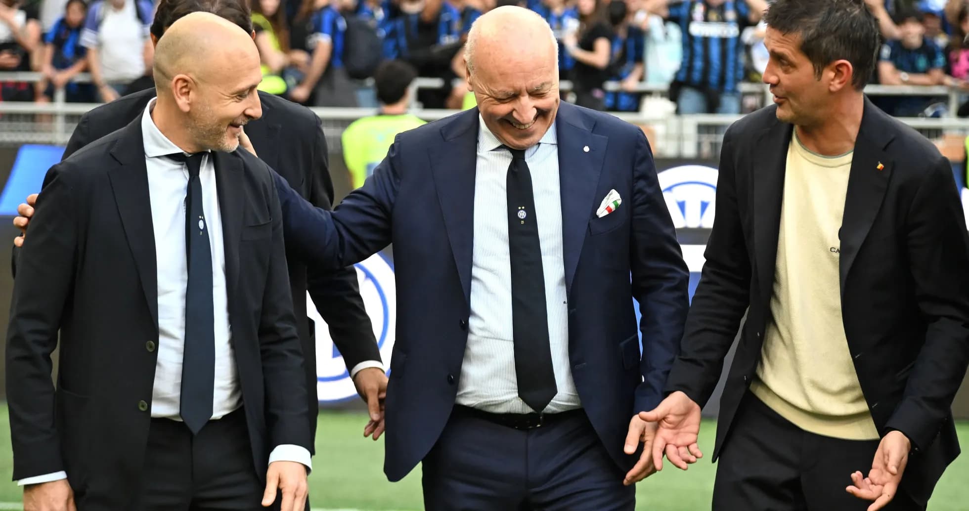 Three men interacting on the pitch before a match Three men interacting on the pitch before a match
