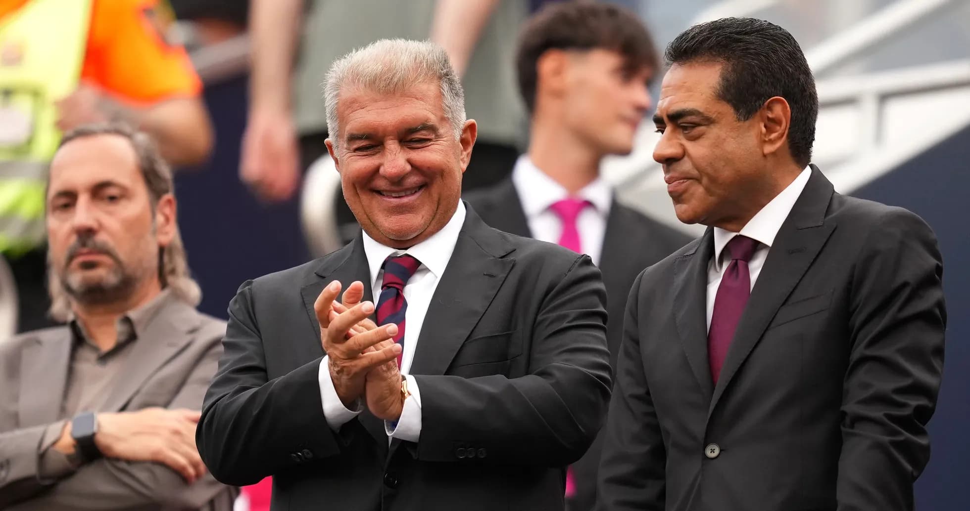 Two men in suits smiling and applauding together Two men in suits smiling and applauding together