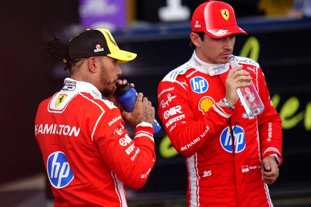 Two drivers in red racing suits drinking water Two drivers in red racing suits drinking water
