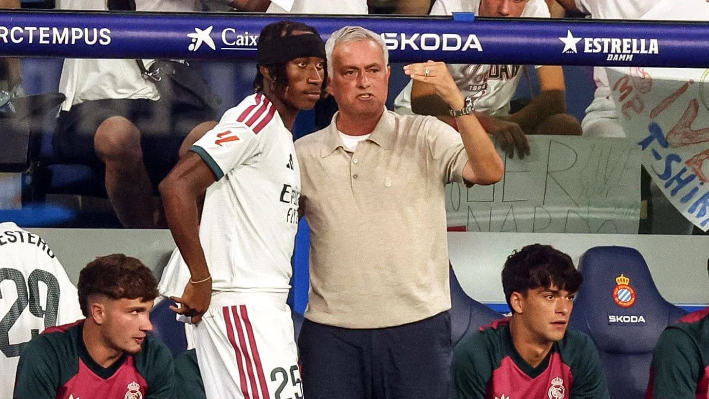 Coach speaking to player on bench during match Coach speaking to player on bench during match